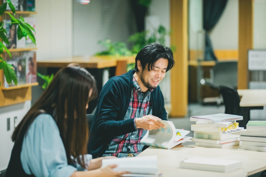 札幌ADC年鑑をめくる岡田さんの写真